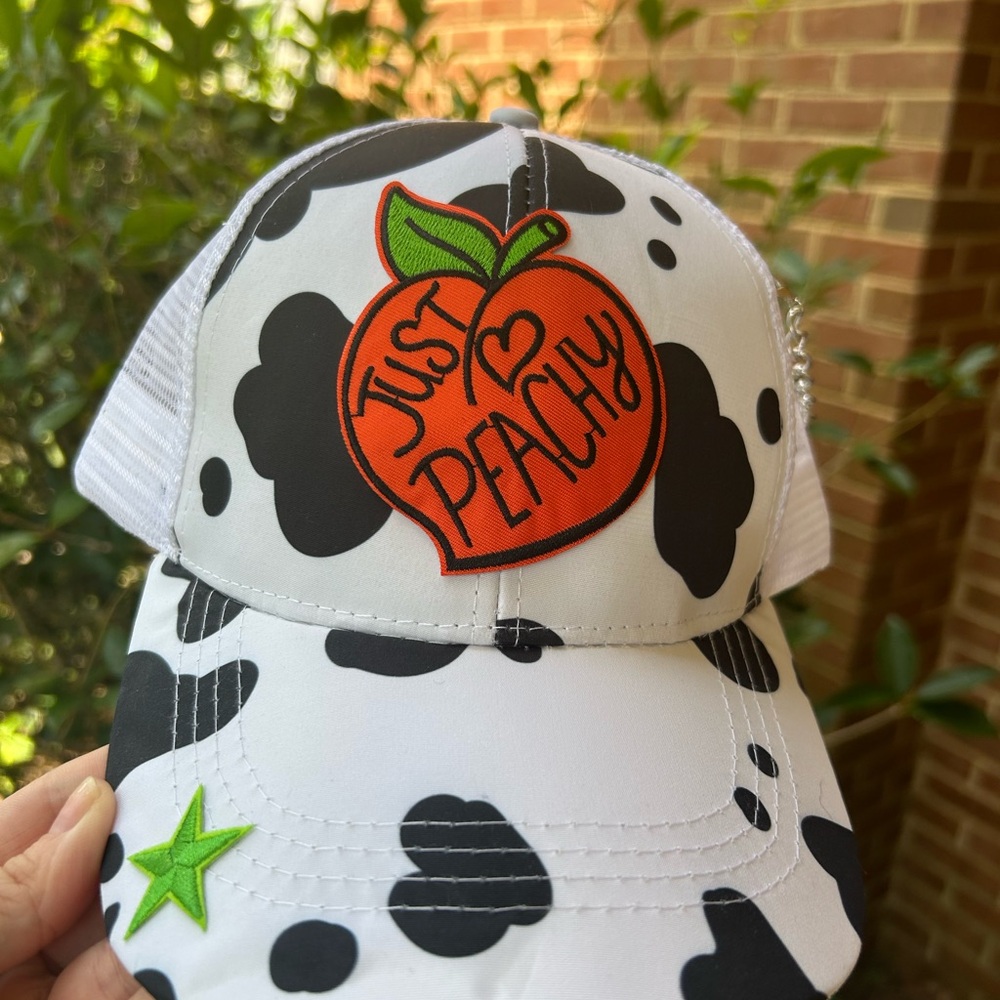 Brand new, cow print trucker hat with Velcro back and pony tail opening. OS